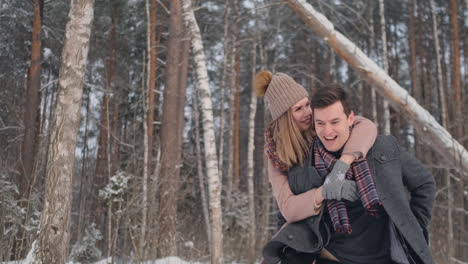 Young-Beautiful-Couple-Taking-Fun-and-Smiling-Outdoors-in-Snowy-Winter